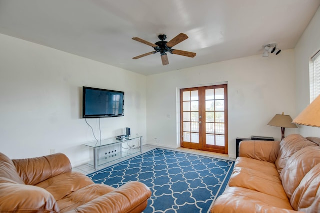 tiled living room featuring ceiling fan and french doors