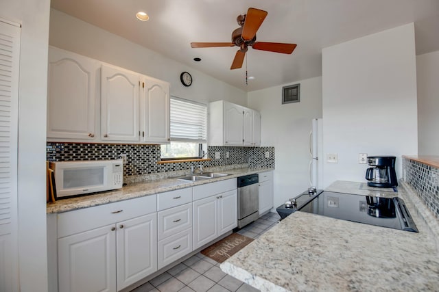 kitchen with sink, white cabinetry, light tile patterned floors, white appliances, and decorative backsplash