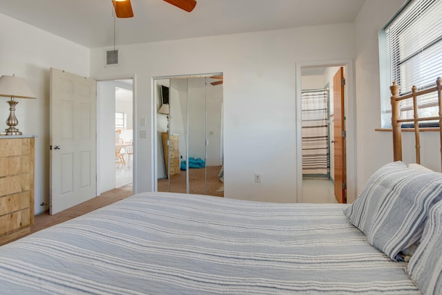 carpeted bedroom featuring ensuite bath, ceiling fan, and a closet