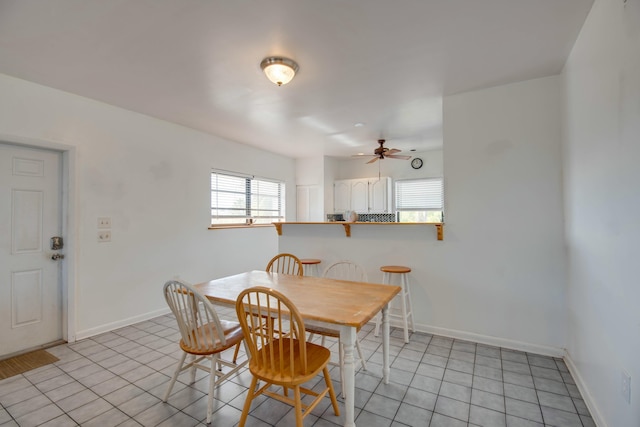 tiled dining space featuring plenty of natural light and ceiling fan