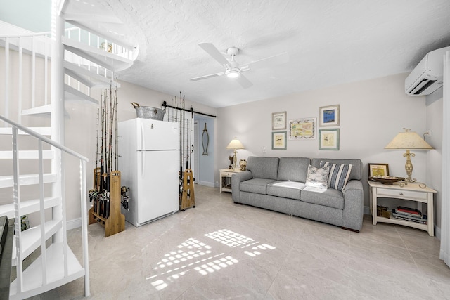 living room featuring a textured ceiling, a wall unit AC, a barn door, and ceiling fan