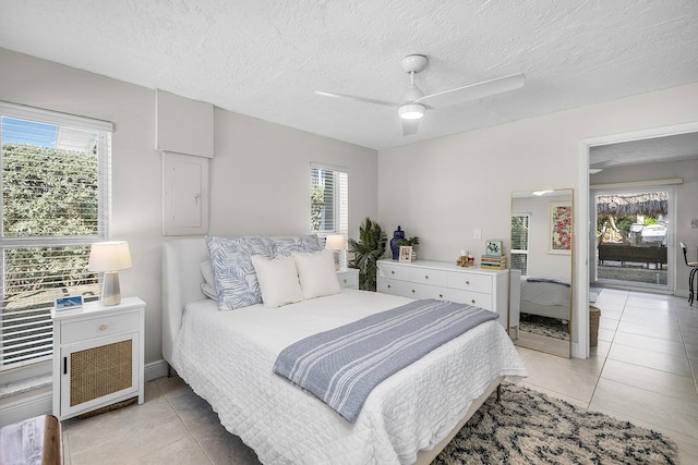 tiled bedroom with ceiling fan and a textured ceiling