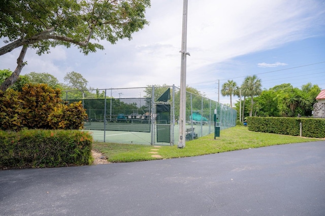 view of tennis court with a yard