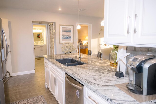 kitchen featuring stainless steel appliances, sink, hardwood / wood-style floors, and white cabinets