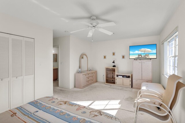 bedroom featuring light carpet, a closet, and ceiling fan