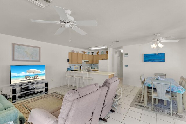 tiled living room with ceiling fan and sink