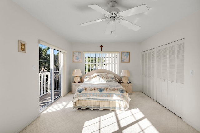 carpeted bedroom featuring ceiling fan, two closets, and access to outside