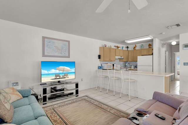 tiled living room with ceiling fan