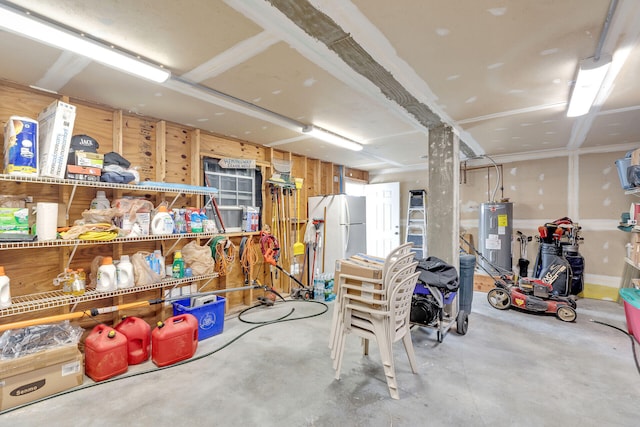 basement featuring electric water heater and white fridge