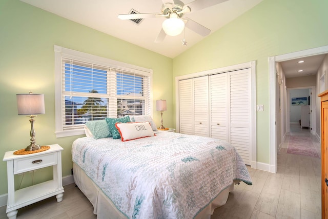 bedroom with vaulted ceiling, ceiling fan, light hardwood / wood-style floors, and a closet