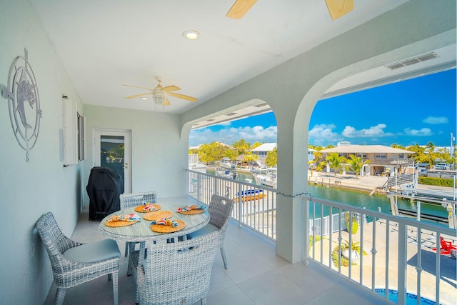 balcony with a water view and ceiling fan