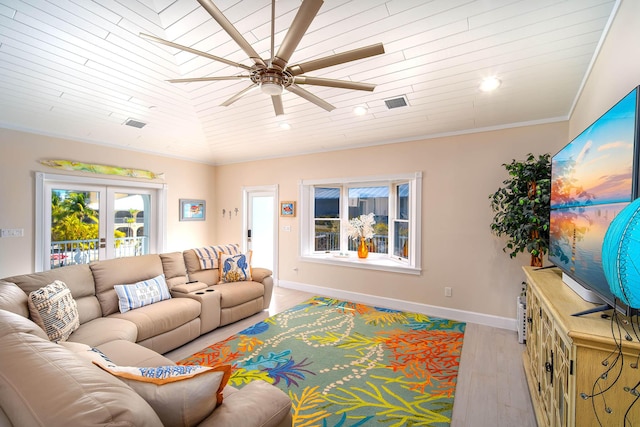 living room featuring light hardwood / wood-style flooring, ceiling fan, ornamental molding, vaulted ceiling, and french doors