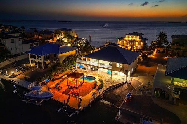 aerial view at dusk featuring a water view