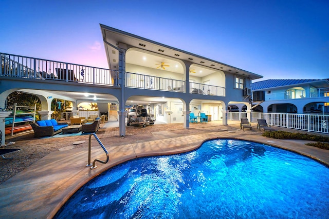 pool at dusk with outdoor lounge area and a patio area