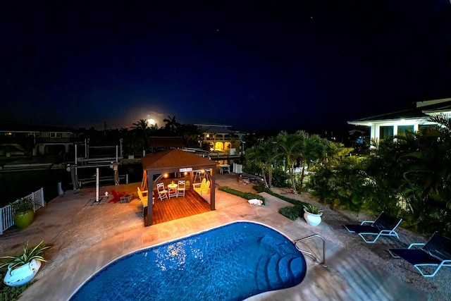 pool at night with a gazebo and a patio area