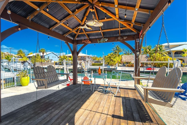 deck with a gazebo, a dock, and ceiling fan