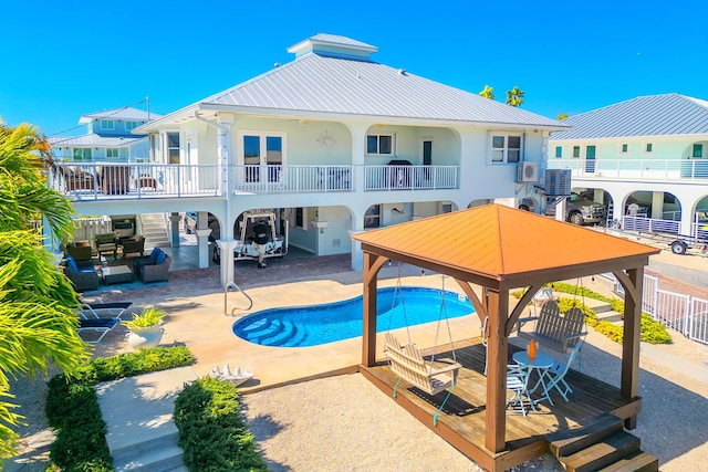 back of property with cooling unit, a gazebo, and a patio area