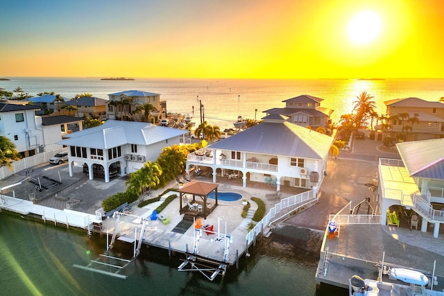 aerial view at dusk featuring a water view