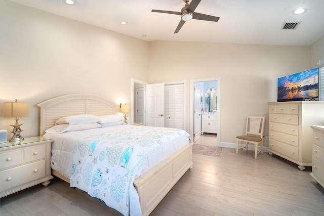 bedroom featuring ensuite bathroom, lofted ceiling, ceiling fan, and light wood-type flooring