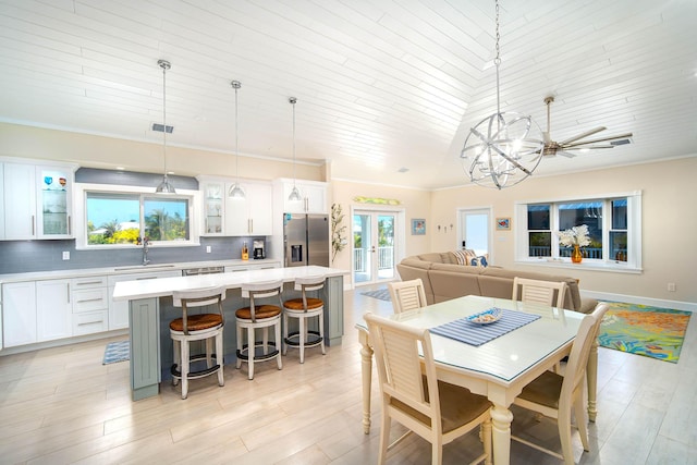 dining room featuring crown molding, sink, light hardwood / wood-style flooring, and french doors