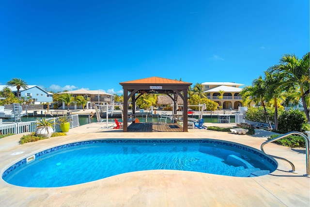 view of pool with a gazebo and a water view