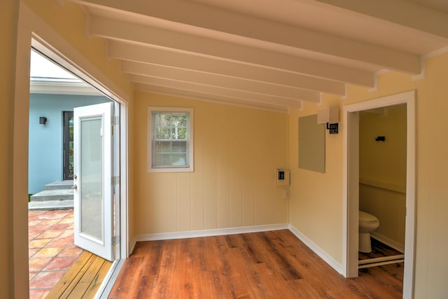 corridor featuring baseboards, beam ceiling, and wood finished floors
