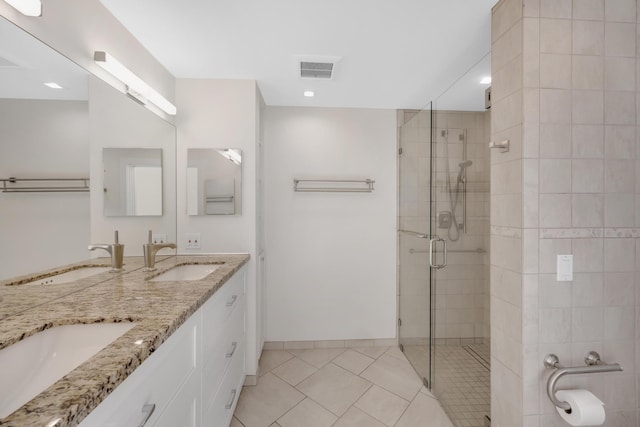 full bath with a sink, tile patterned floors, a shower stall, and visible vents