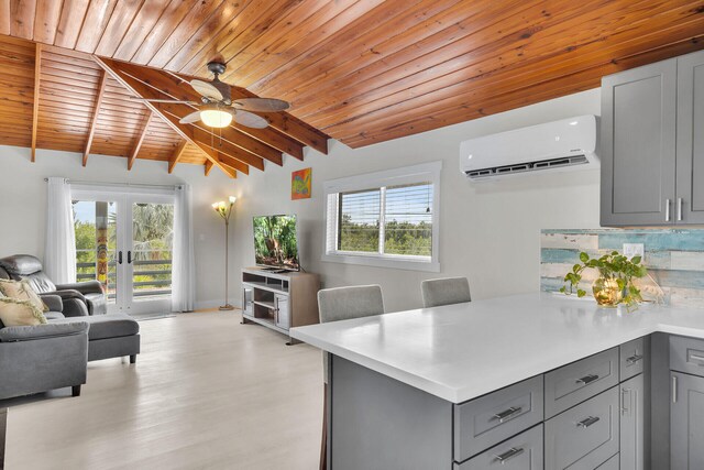 kitchen with open floor plan, light countertops, a wall unit AC, and gray cabinetry