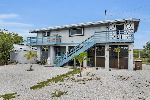 rear view of property featuring stairway and a deck