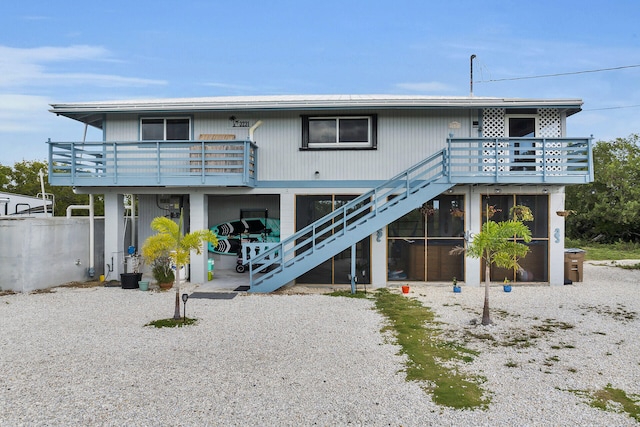 view of front of house with stairs, a carport, a deck, and driveway