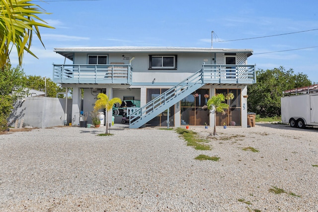 coastal home featuring stairway and a wooden deck