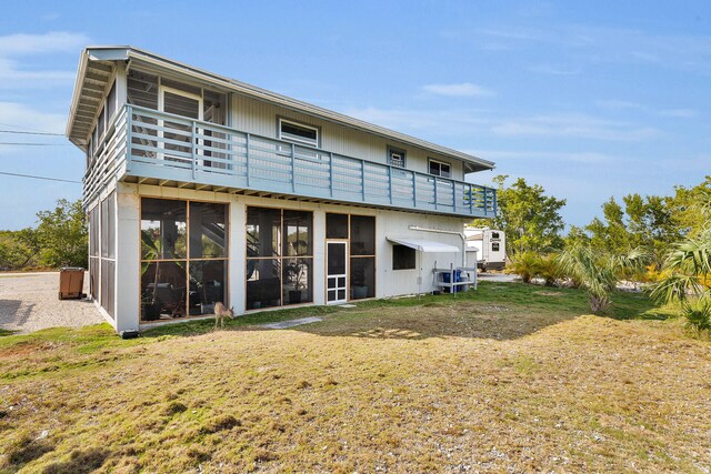 back of house featuring a sunroom and a yard