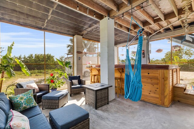 view of patio with a hot tub, outdoor dry bar, and an outdoor living space