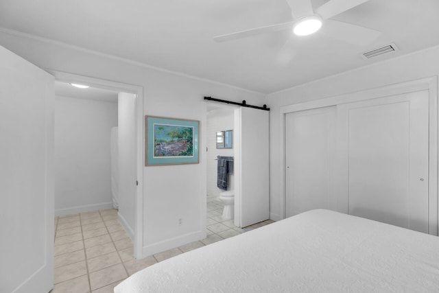 1513 5th St, Key West, FL 33040 - bedroom featuring light tile patterned flooring, a barn door, a closet, connected bathroom, and baseboards