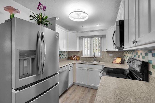 1513 5th St, Key West, FL 33040 - kitchen featuring stainless steel appliances, a sink, white cabinetry, decorative backsplash, and light countertops