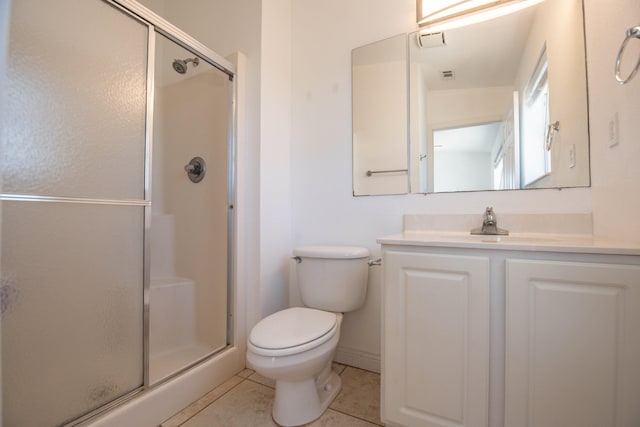 bathroom featuring tile patterned flooring, vanity, a shower with shower door, and toilet