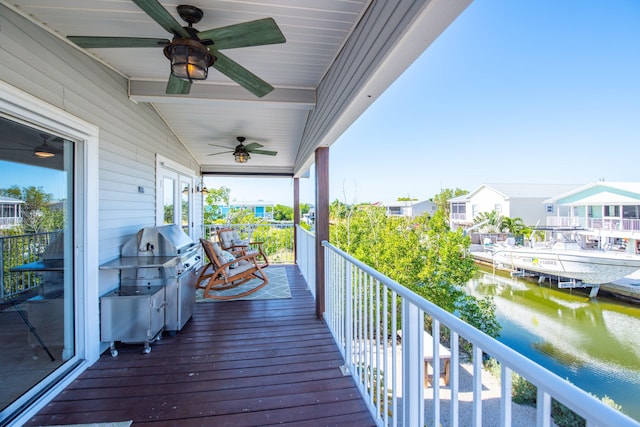 wooden terrace featuring a water view and ceiling fan