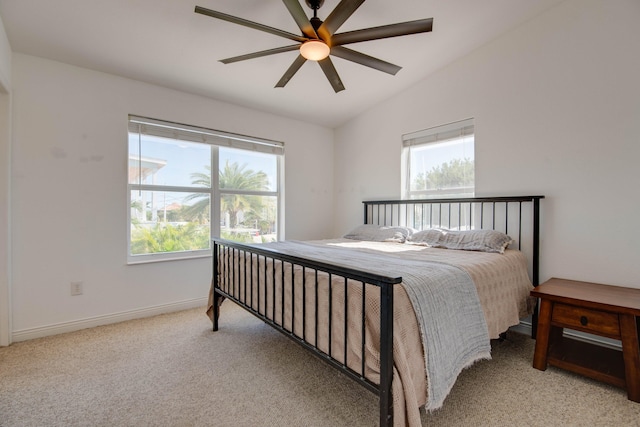 bedroom featuring multiple windows, lofted ceiling, light carpet, and ceiling fan