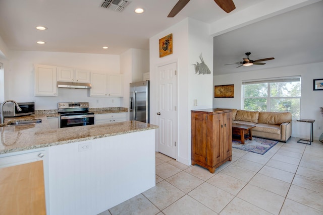 kitchen with appliances with stainless steel finishes, sink, white cabinets, kitchen peninsula, and light stone countertops