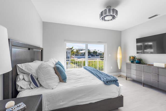 bedroom with light wood-type flooring and access to outside