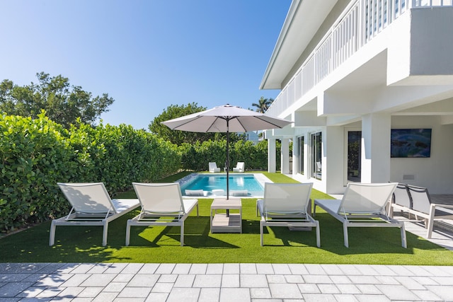 view of pool with a patio and a yard