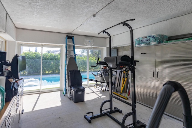 exercise area with electric panel and a textured ceiling