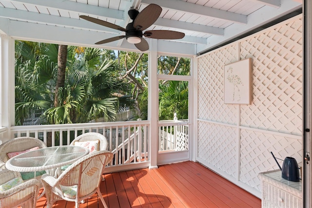 sunroom featuring beamed ceiling and ceiling fan