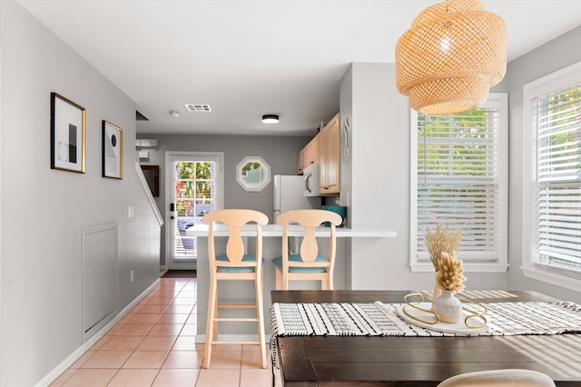 dining space with light tile patterned floors, visible vents, and baseboards