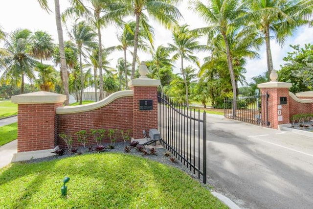 community sign featuring a gate and a lawn