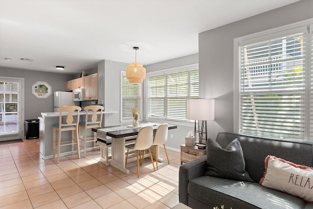 dining room featuring light tile patterned floors, visible vents, and baseboards