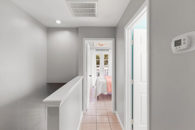 corridor featuring french doors, visible vents, an upstairs landing, and light tile patterned flooring