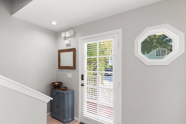 entryway with light tile patterned flooring and baseboards