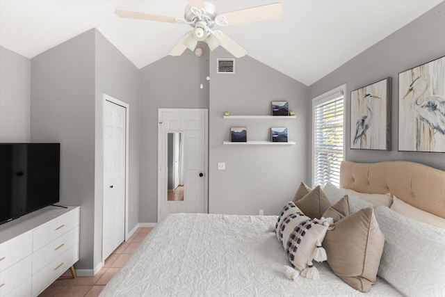 bedroom with lofted ceiling, ceiling fan, light tile patterned flooring, visible vents, and baseboards