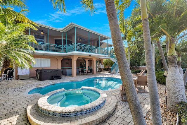 outdoor pool featuring a ceiling fan, outdoor dining area, an outdoor hot tub, and a patio